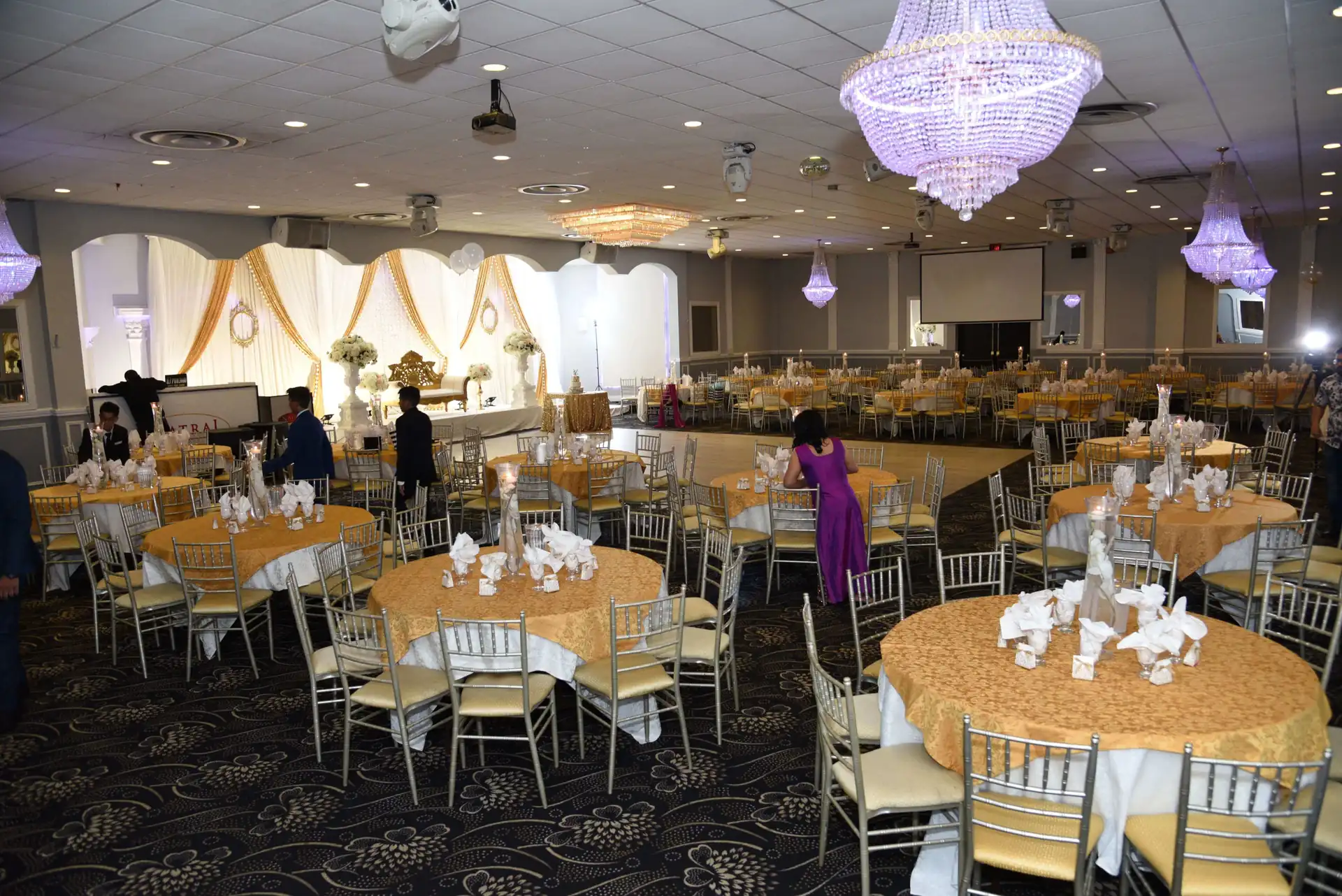Gold chiavari chairs at dressed round tables before guests arrive.