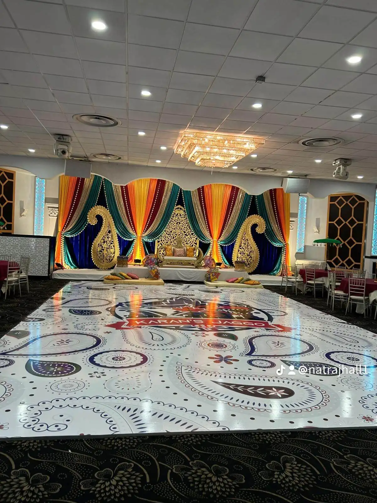 Mandala-patterned dance floor projected in colour across the ballroom.