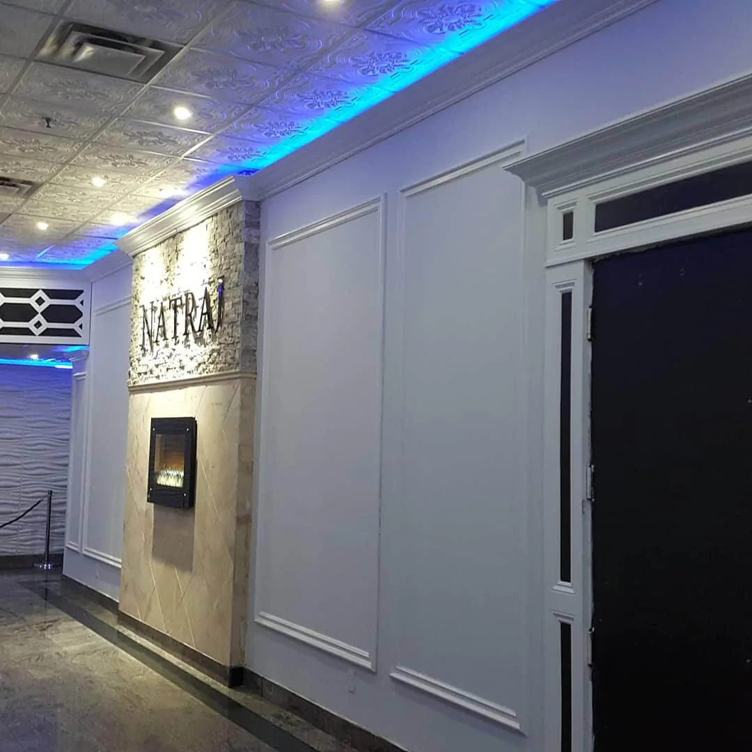 Blue-lit corridor connecting the lobby to the event rooms.