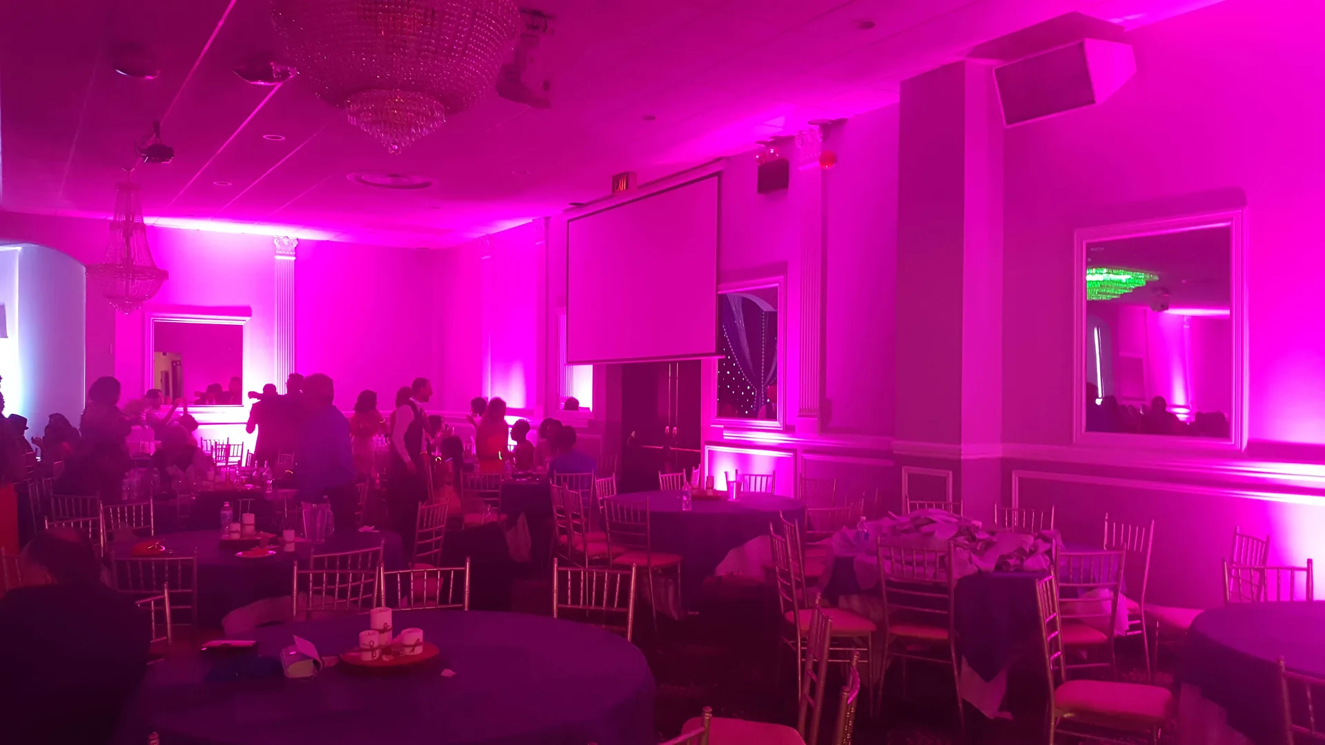 Rose-pink uplighting along the ballroom walls for an evening reception.