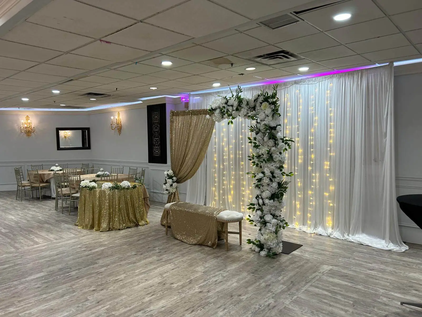 Reception decor in gold and white, with a draped head table.