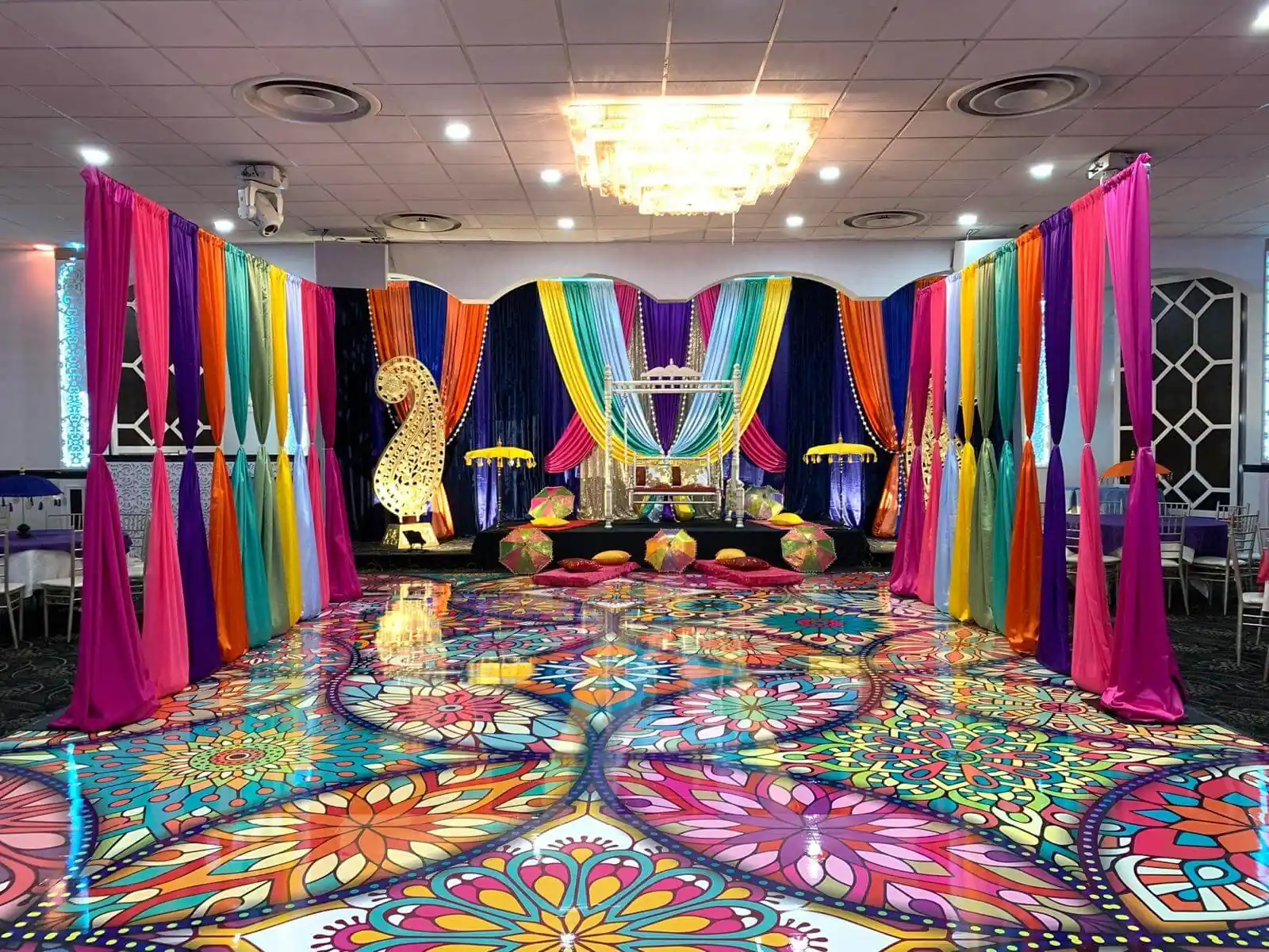 Patterned dance floor lit in changing colour under the Grand Ballroom's lighting rig.