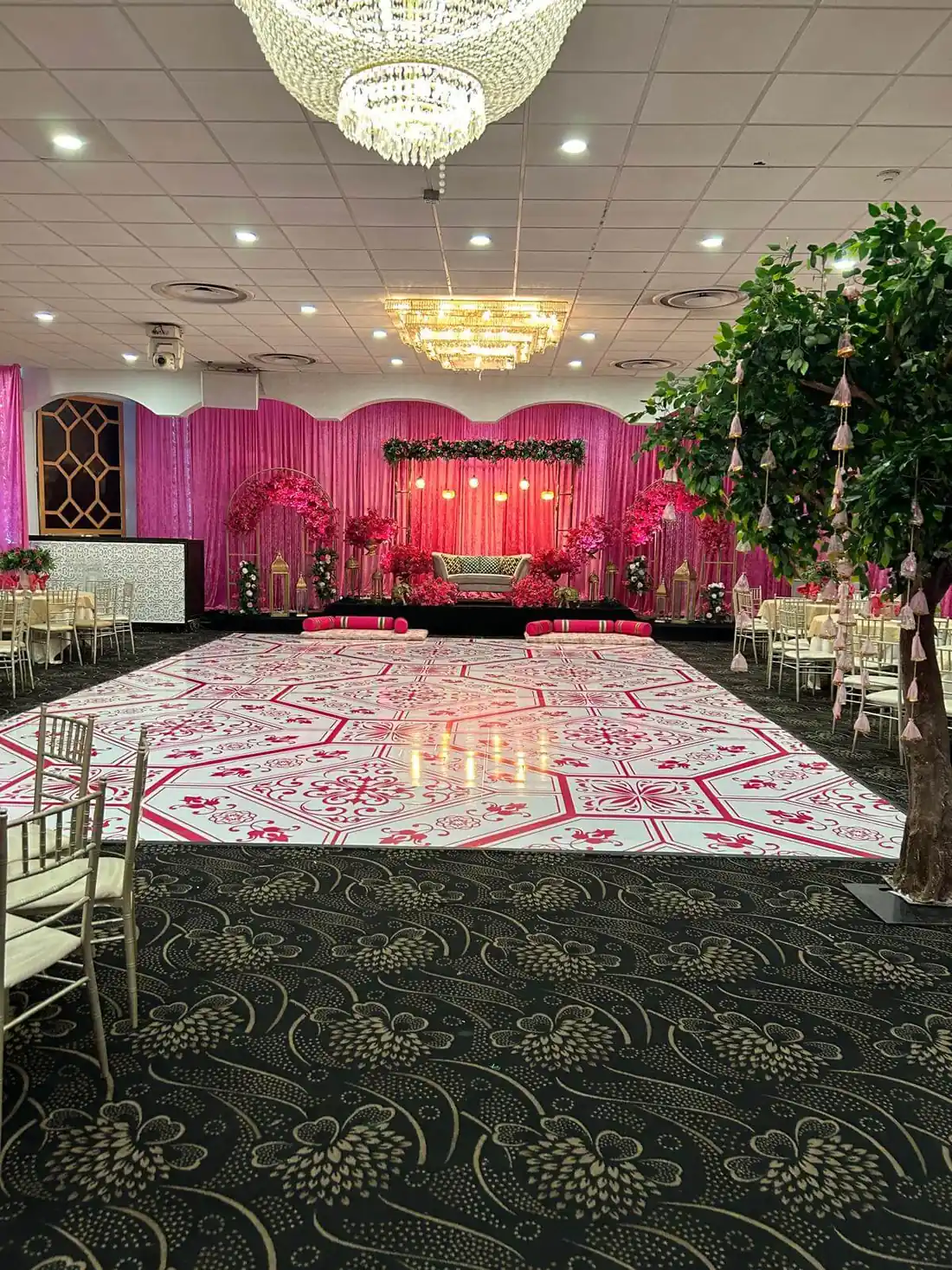 Geometric dance floor design in the Grand Ballroom, with tables set around the perimeter.