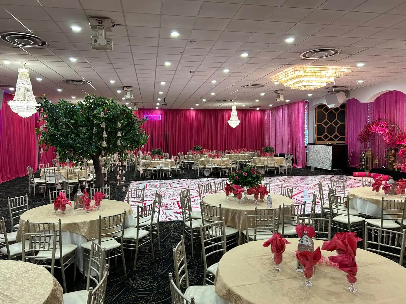The Grand Ballroom washed in pink uplighting, tables laid for a reception.