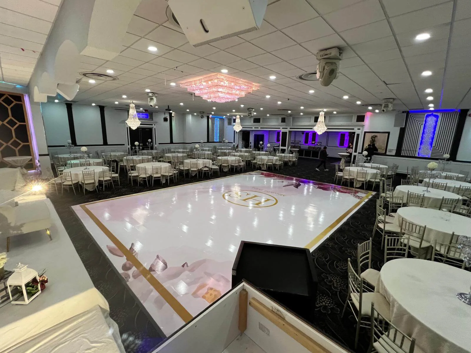 White dance floor at the centre of the Grand Ballroom, ringed by set dining tables.