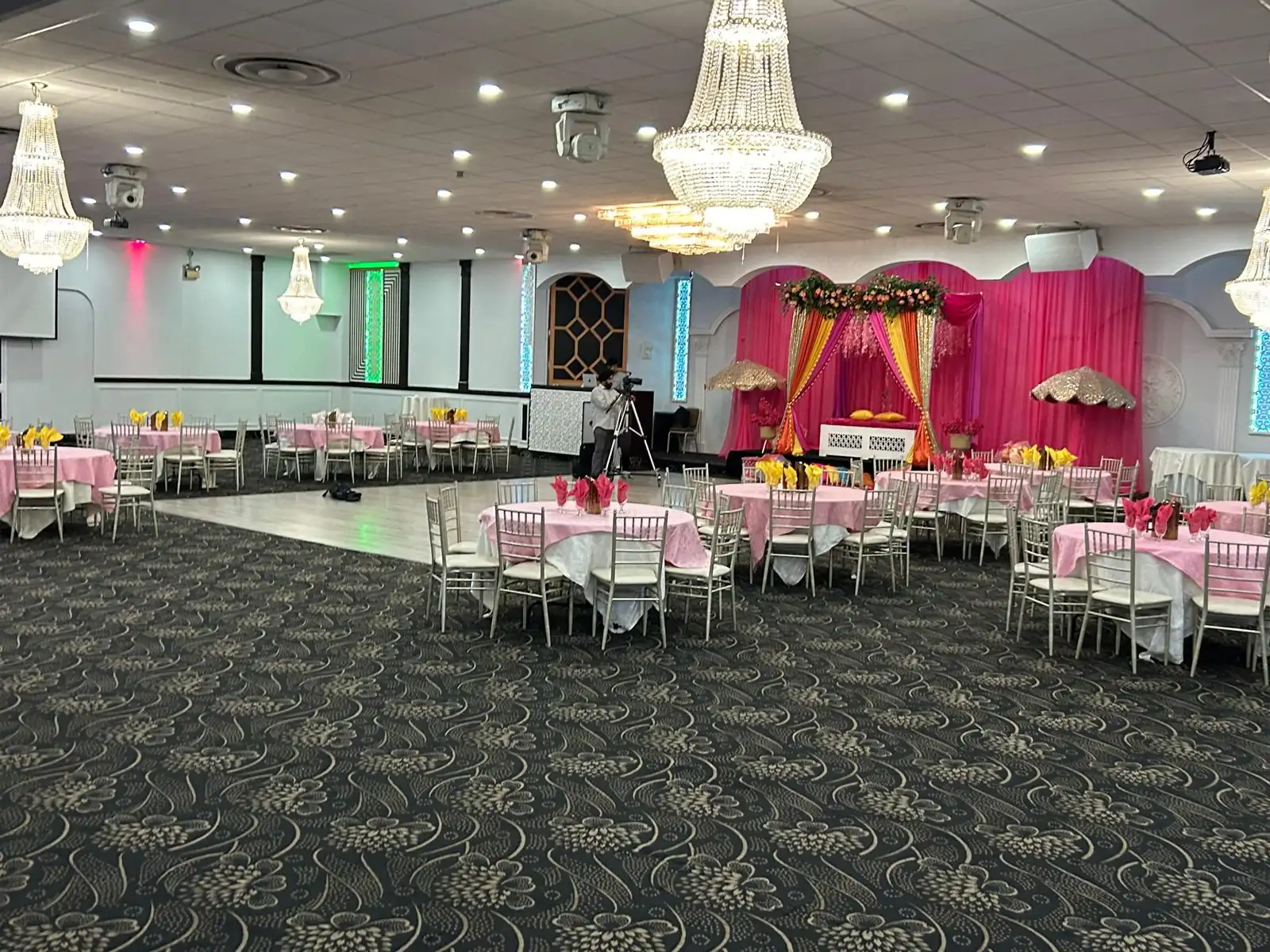 Stage dressed in pink drapery and florals for an engagement.