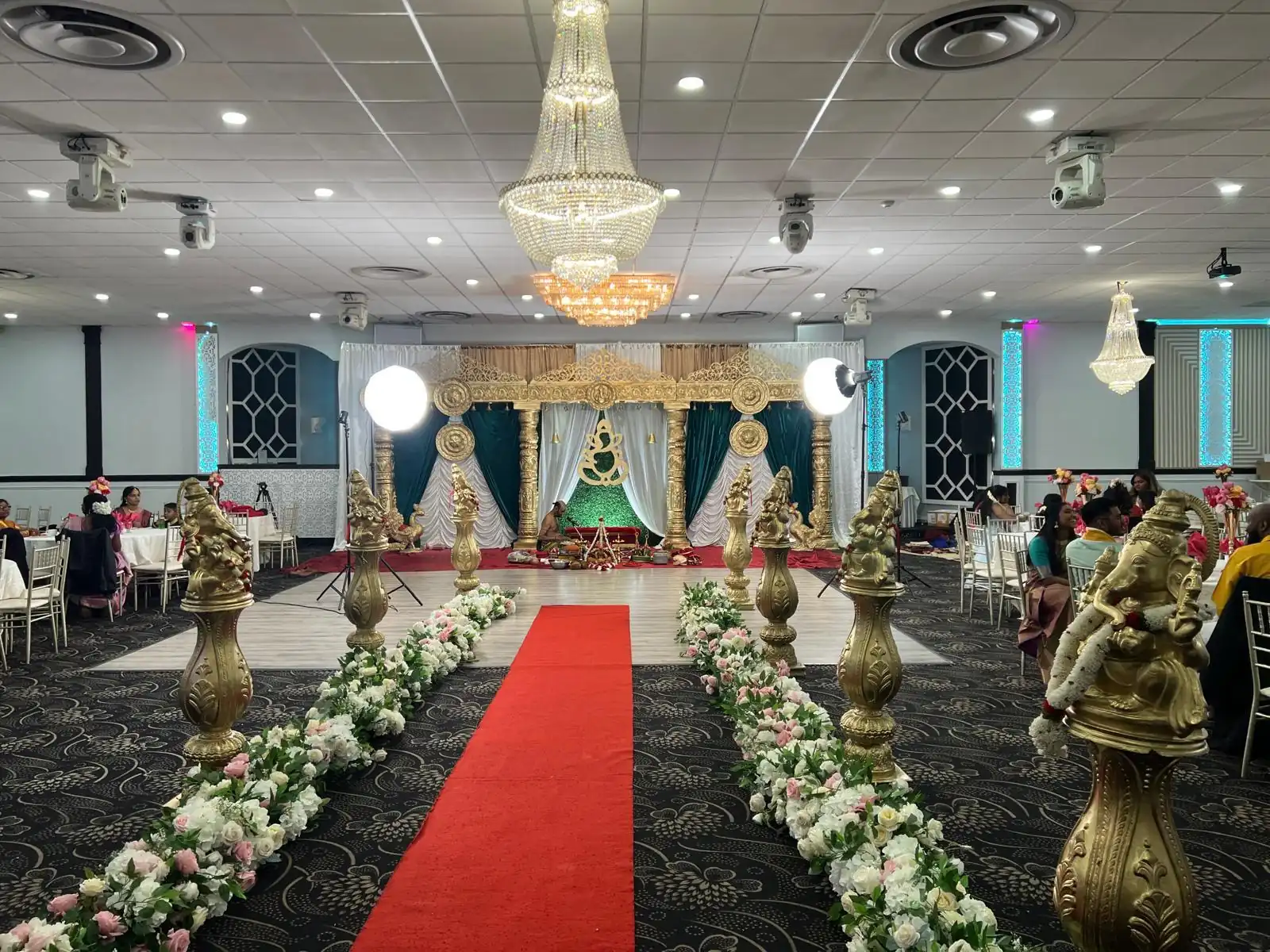 Aisle lined with floral arrangements leading to the ceremony stage.